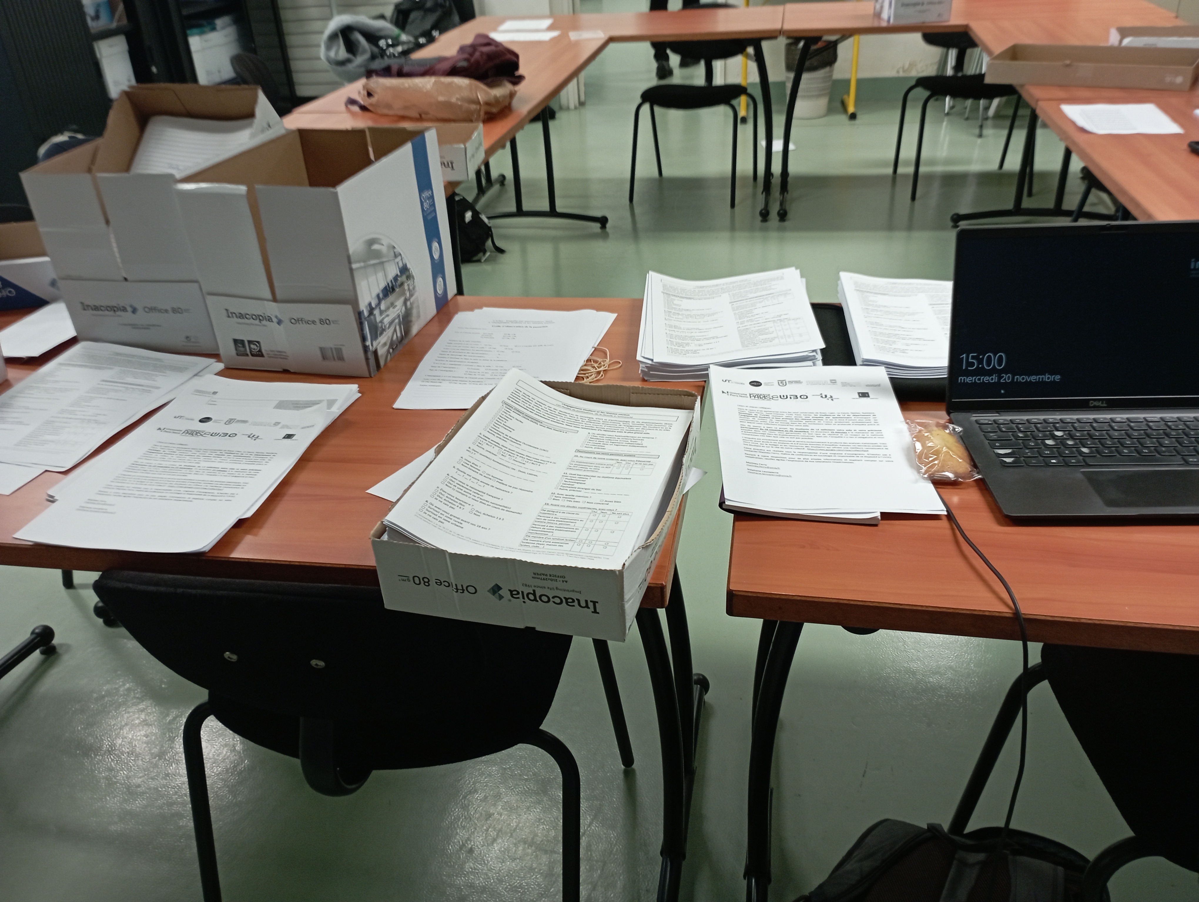 Piles de questionnaires et écran d'ordinateur